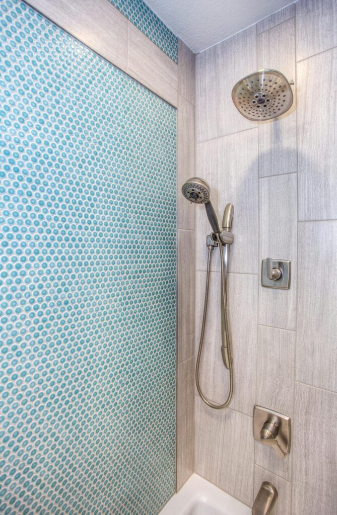 Aplicación y pegado de azulejo con adhesivo blanco en baño con ducha
