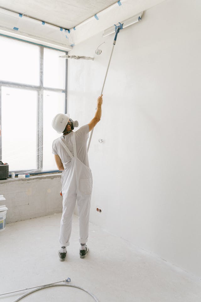 Servicios de construccion, remodelacion y mantenimiento para el hogar y la oficina. Hombre aplicando un acabado a base de pintura vinilica en muros y plafones.